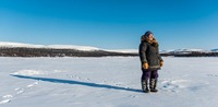 Inuit woman looking for fishing spot around Kangiqsualujjuaq, Canada