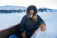 Inuit woman in sledge in Kangiqsualujjuaq, Canada