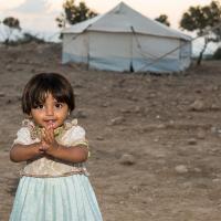 Syrian refugee girl is standing by her "home" in an informal settlement in Jordan Valley, Jordan.