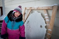 Inuit girl and seal skin in Kuujjuaq, Canada