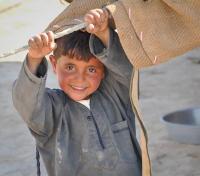 A young boy and already a climate-migrant by his tent in the outskirts of Palmyra, Syria.